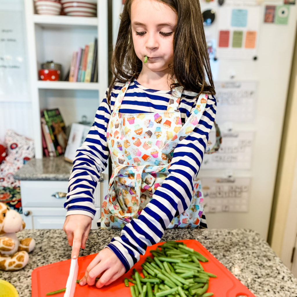 Five benefits of having kids help it the kitchen. From building vocabulary to enjoying fun new sensory experiences, cooking with little ones in the kitchen is so much fun! #cookingwithkids #kidscooking #bakingwithkids #kidsinthekitchen